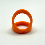 An orange 3D-printed ring shown on a neutral gray background.