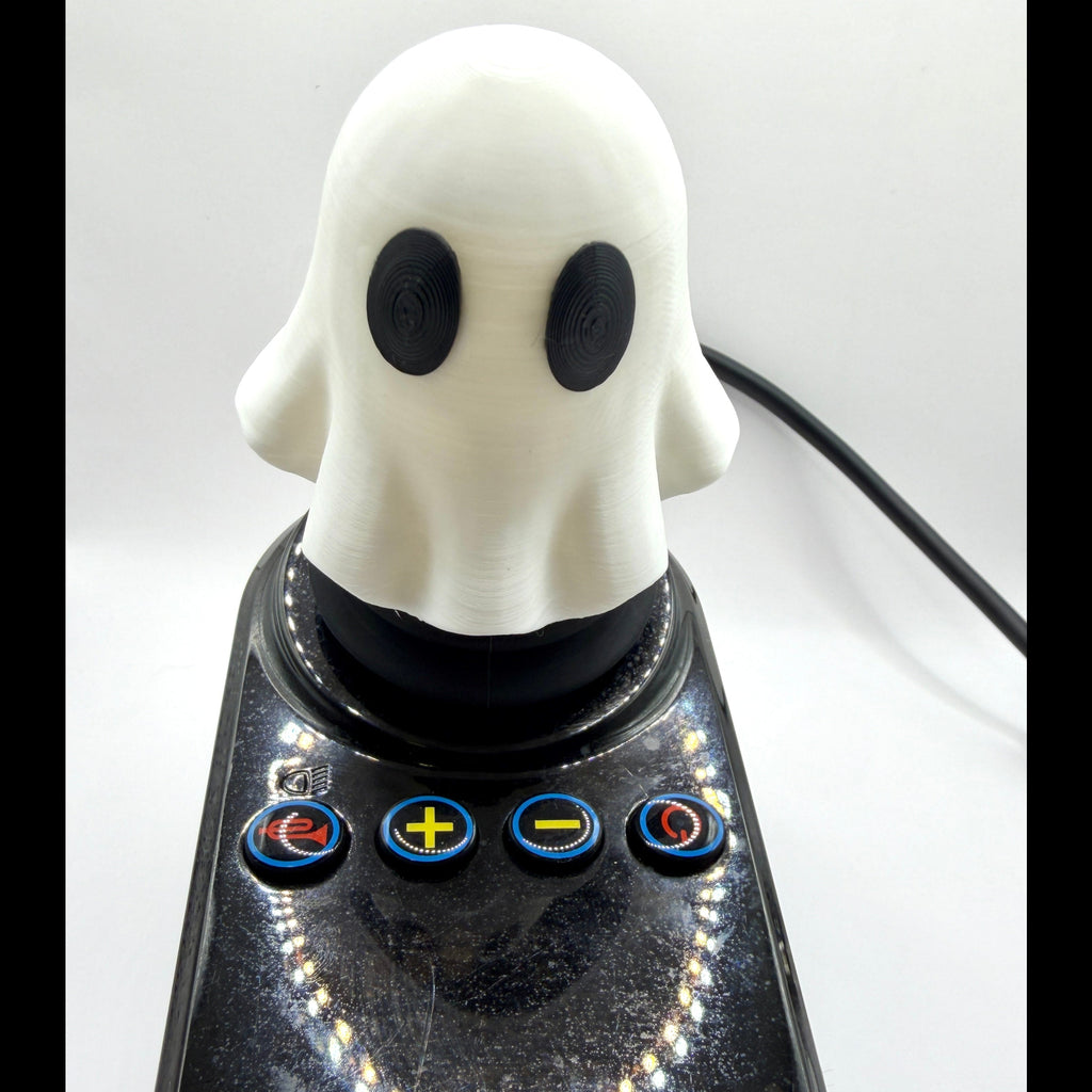 A ghost-shaped joystick with a white ghost head and black eyes mounted on a glossy black base with four blue control buttons, shown against a plain white background.