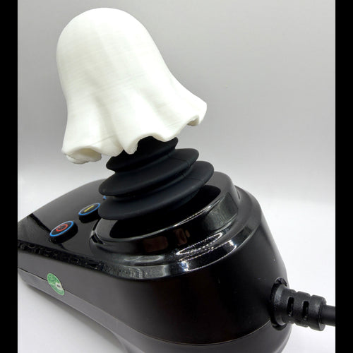 A novelty ghost-shaped joystick with a white ghost head and black stalk, mounted on a glossy black base with buttons and a power cord, shown against a light gray background.