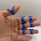 A hand wearing blue finger rings with purple iridescent accents on the thumb, shown against a plain light background.