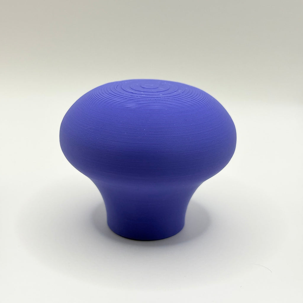 A single mushroom-shaped blue product, likely a 3D-printed knob or handle, centered on a light gray studio background.