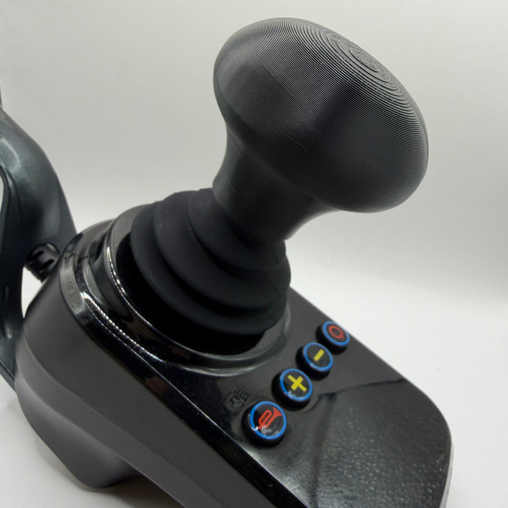 A black joystick control with a textured mushroom shaped grip and four blue buttons featuring red, yellow, and green symbols, shown on a white background.