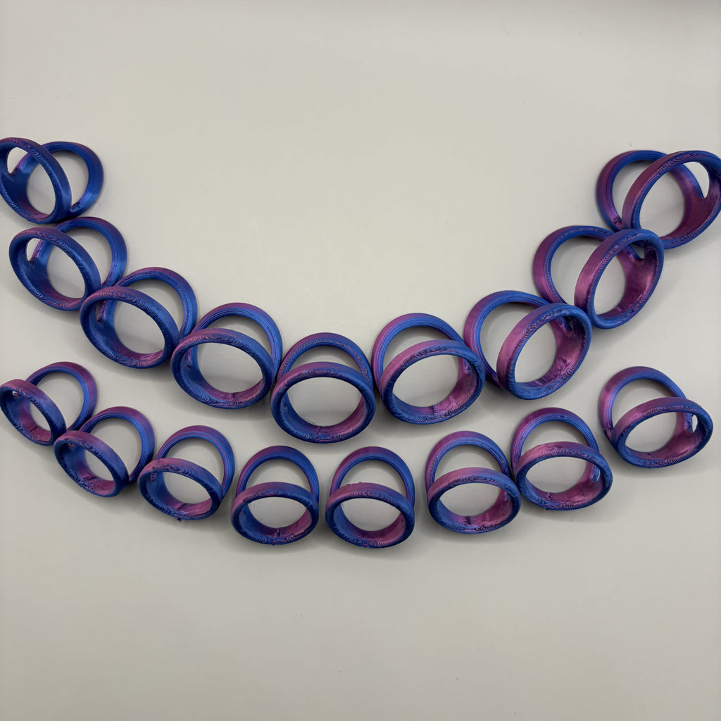 A set of ring stabilizers in a blue and purple marbled pattern, arranged in two curved rows on a plain light gray background.